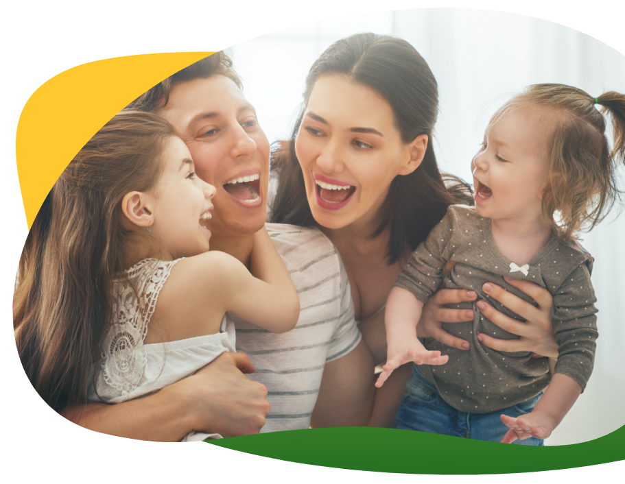 Dobre naladená mladá rodina sa po užití Espumisanu bezstarostne usmieva: Rodičia držia svoje deti v náručí, v popredí je balenie Espumisanu v rôznych liekových formách, pre rôzne potreby